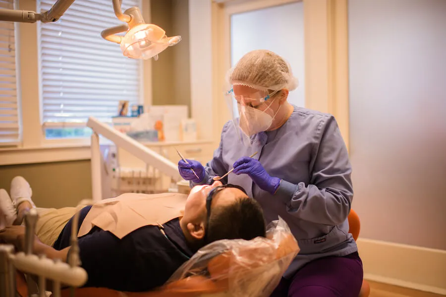 Une hygiéniste effectuant un détartrage